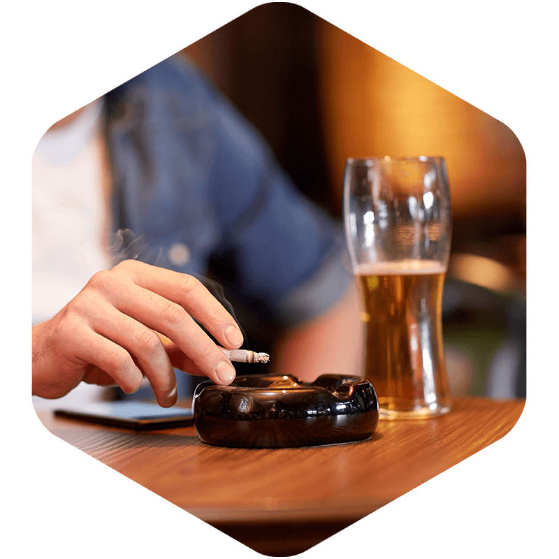 Person smoking and drinking beer.